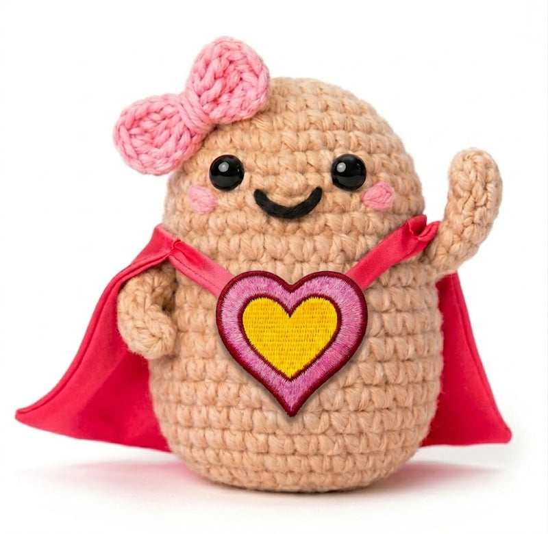 Power Woman, amigurumi all'uncinetto con fiocco rosa, mantello rosso e cuore ricamato